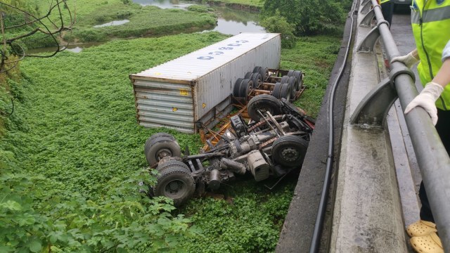 台风席卷路面湿滑甬台温高速一货车倒翻跌下桥面消防员冒雨施救